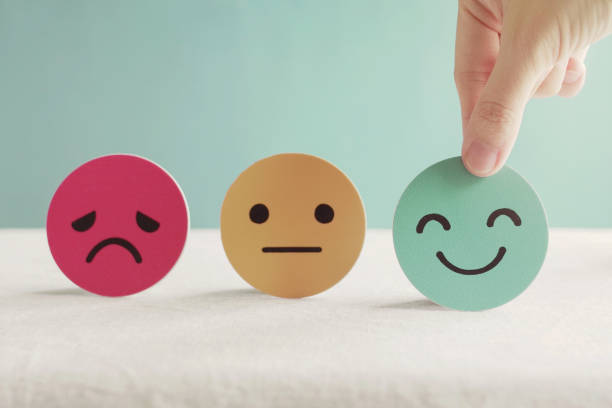 Imagen que muestra tres iconos de emociones. Una mano selecciona el tercer emoticono