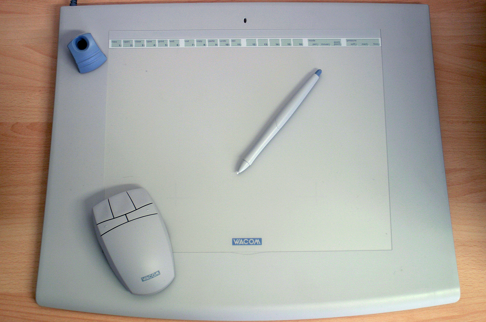 Tableta digitalizadora blanca y sobre ella, un ratón y un lápiz digital.