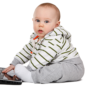 Bebé sentado delante de un ordenador portátil mirando a cámara