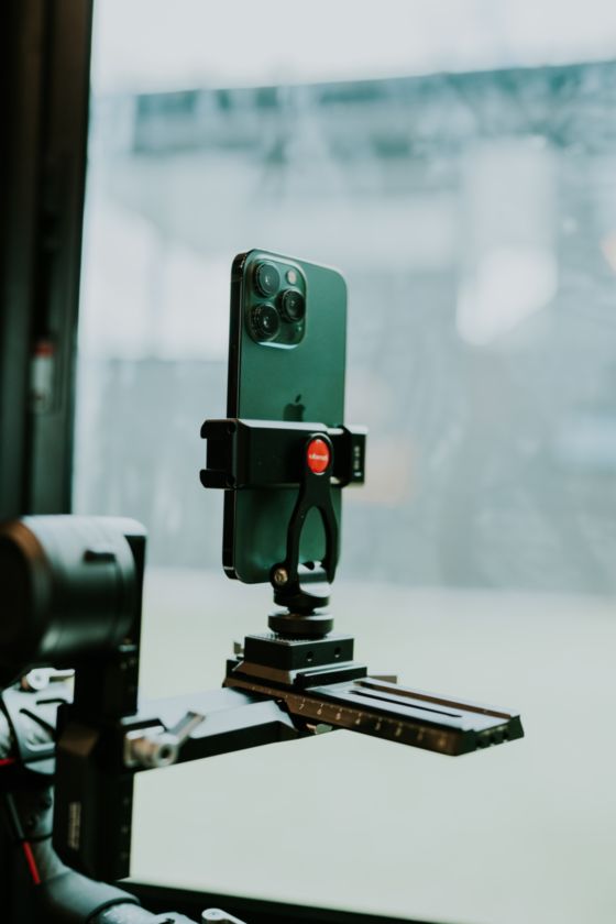 En la fotografía aparece un tripode que sostiene un móvil para poder grabar o realizar fotografías con mayor precisión y calidad.