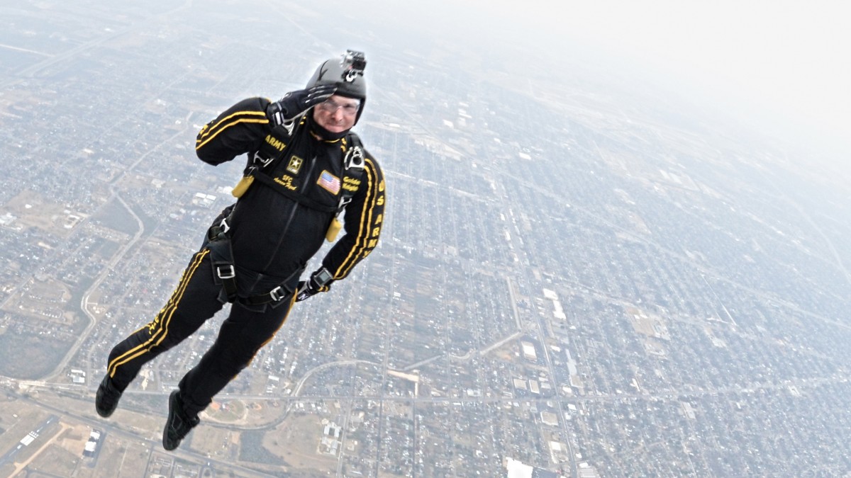 La imagen muestra una persona tirándose en paracaídas