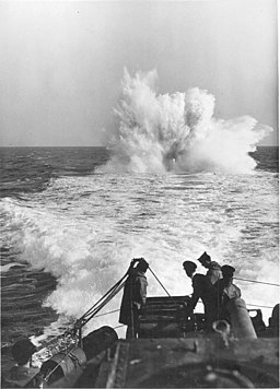 Barco lanzando cargas de profundidad para destruir submarinos.