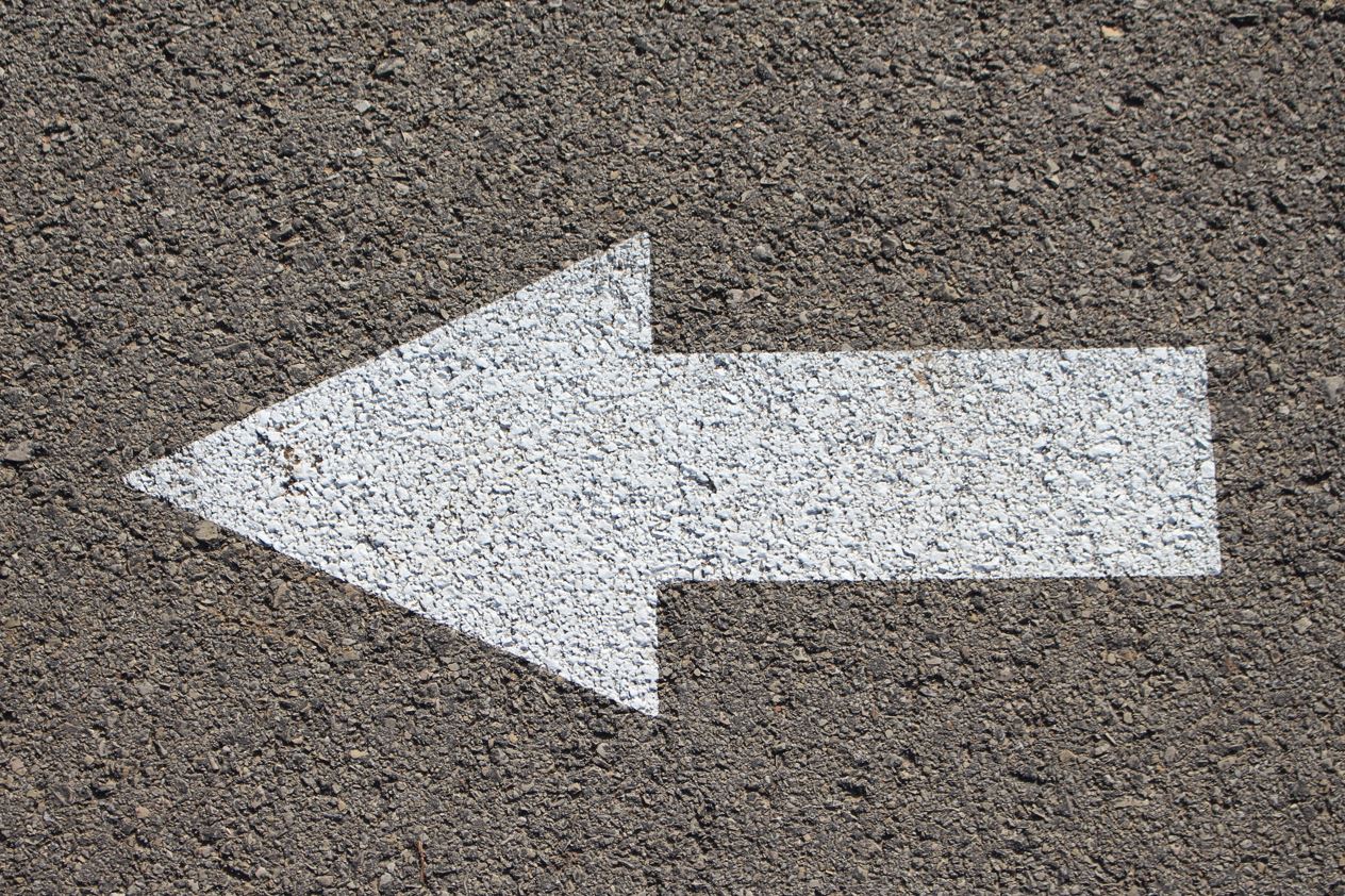La imagen muestra una flecha pintada en la carretera hacia la izquierda.