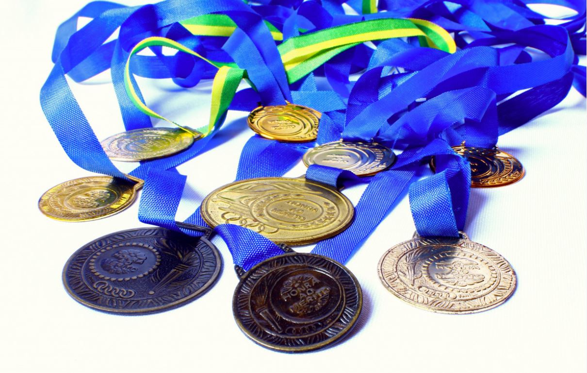 La imagen muestra diferentes medallas de oro, plata y bronce.