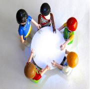 La imagen muestra desde arriba cinco muñecos sentados alrededor de una mesa redonda.