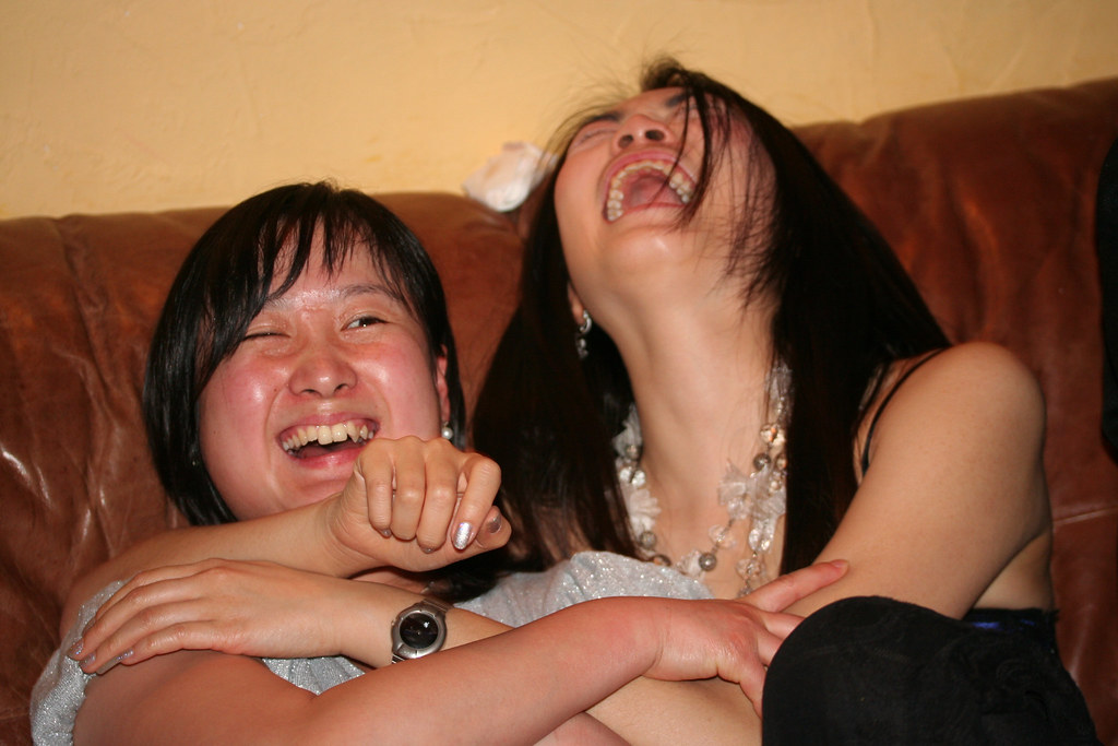 La imagen muestra a dos personas abrazadas y riéndose a carcajadas.