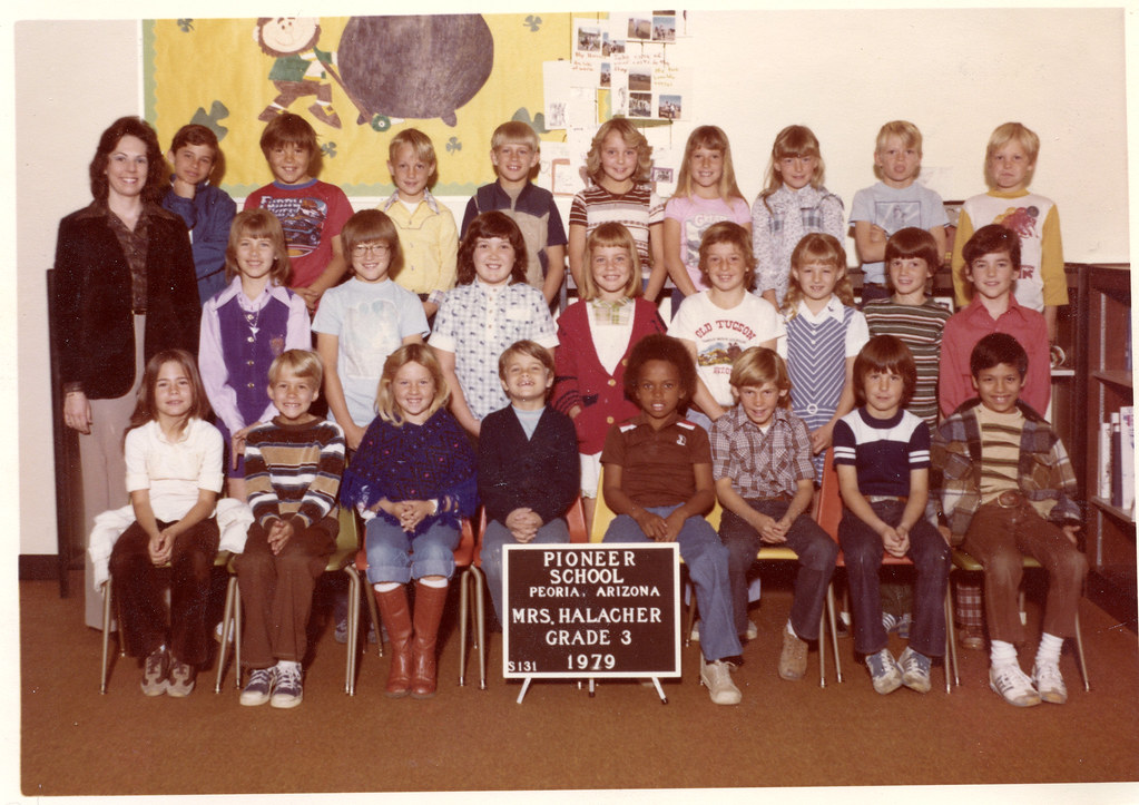 La imagen muestra una foto de clase de primaria.