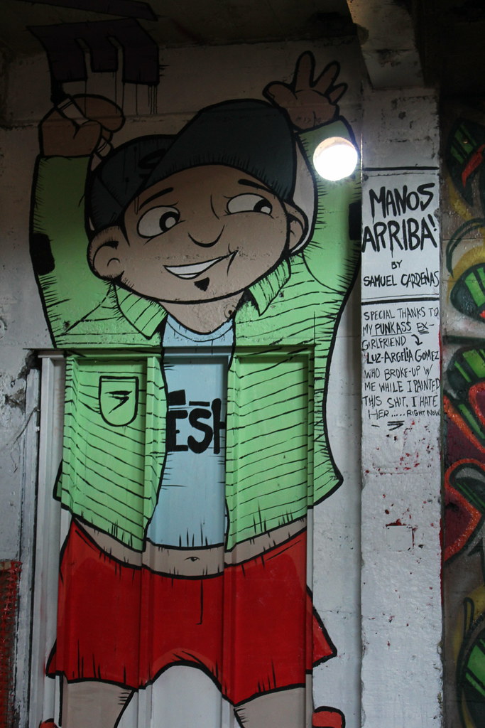 La imagen mustra la pintura de un muñeco con las manos arriba.