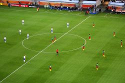 Inicio de un partido de fútbol con los dos equipos, uno frente al otro.