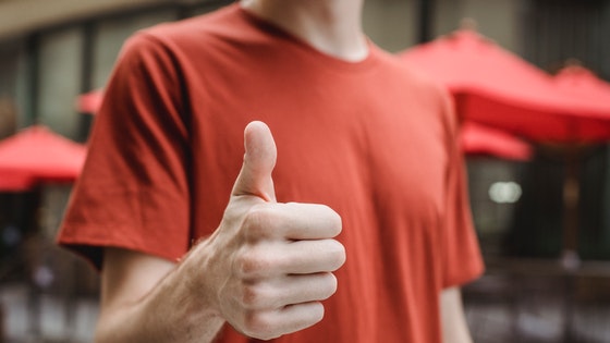 La imagen muestra la mano de un chico con el puño cerrado y el dedo pulgar hacia arriba.
