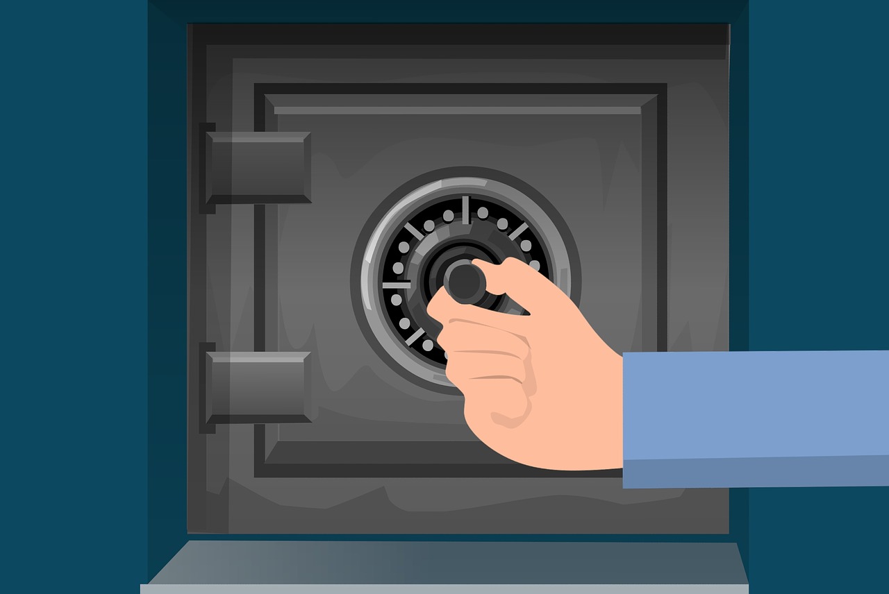 La imagen muestra el dibujo de una caja fuerte y una mano girando la rueda de la combinación de seguridad