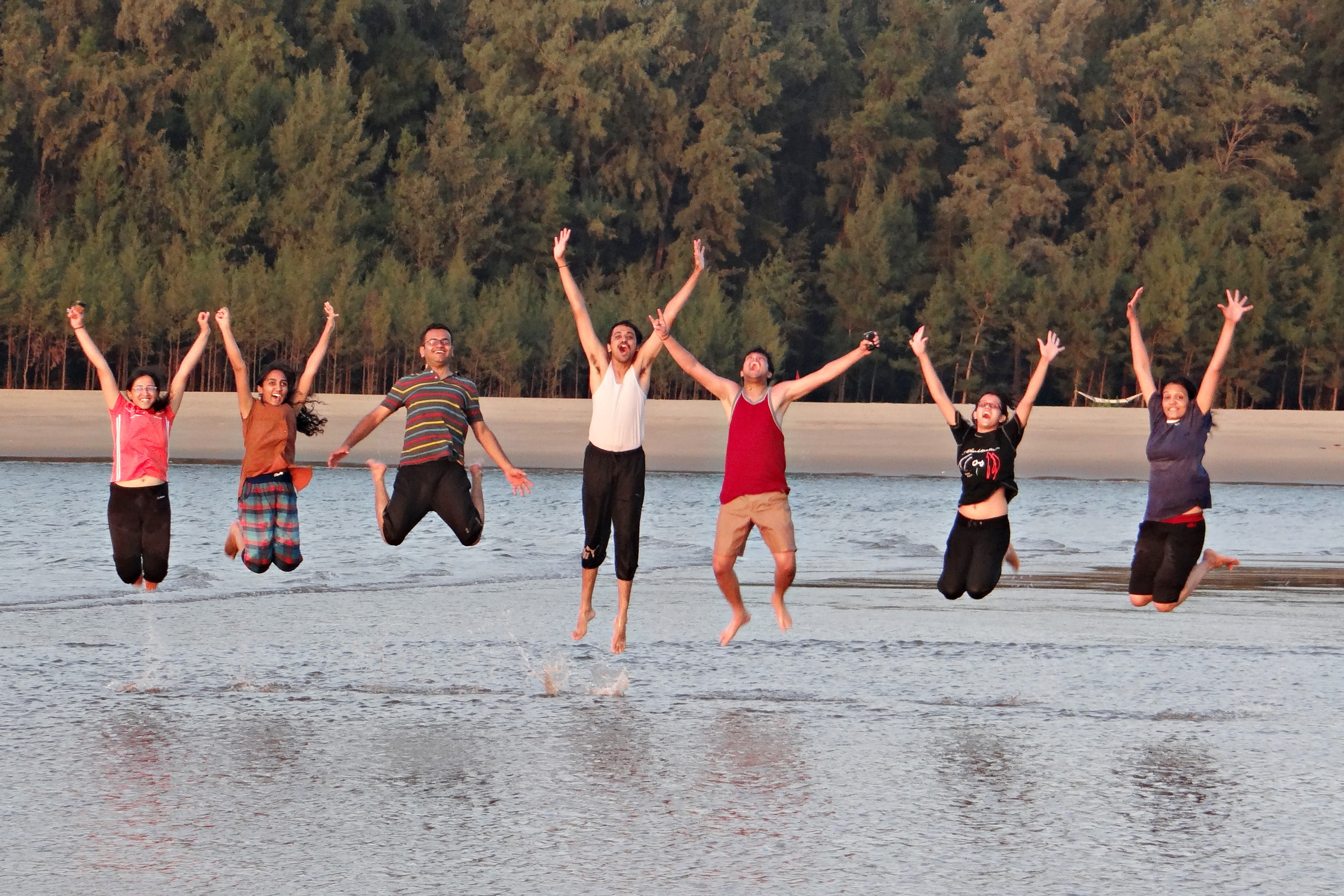 La imagen muestra varias personas saltando y con los brazos levantados muy felices