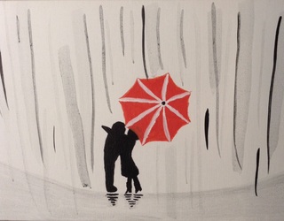 Dos personas bajo en paraguas besándose
