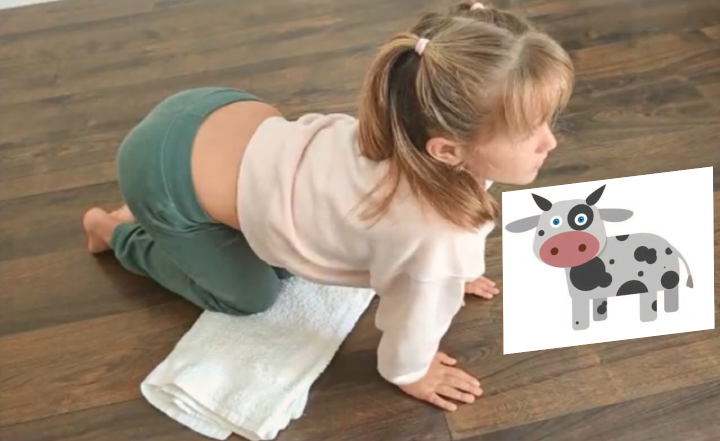 La imagen muestra a una niña realizando en yoga la postura de la vaca