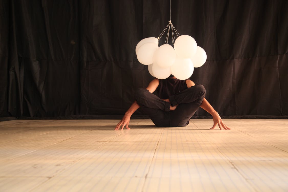 Persona en posición de yoga con globos