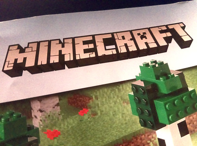 Logo Minecraft. Videojuego con POO en el que aparece el nombre del juego y una construcción con bloques. 