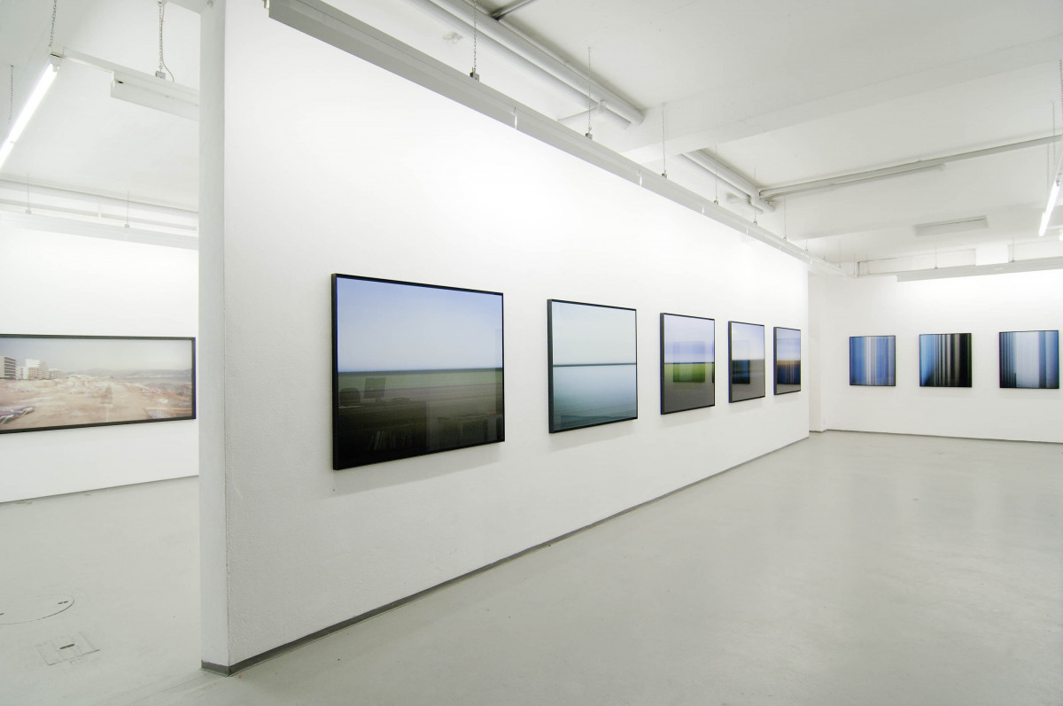 La imagen muestra una sala de exposiciones con muchas fotografías colgadas en las paredes.