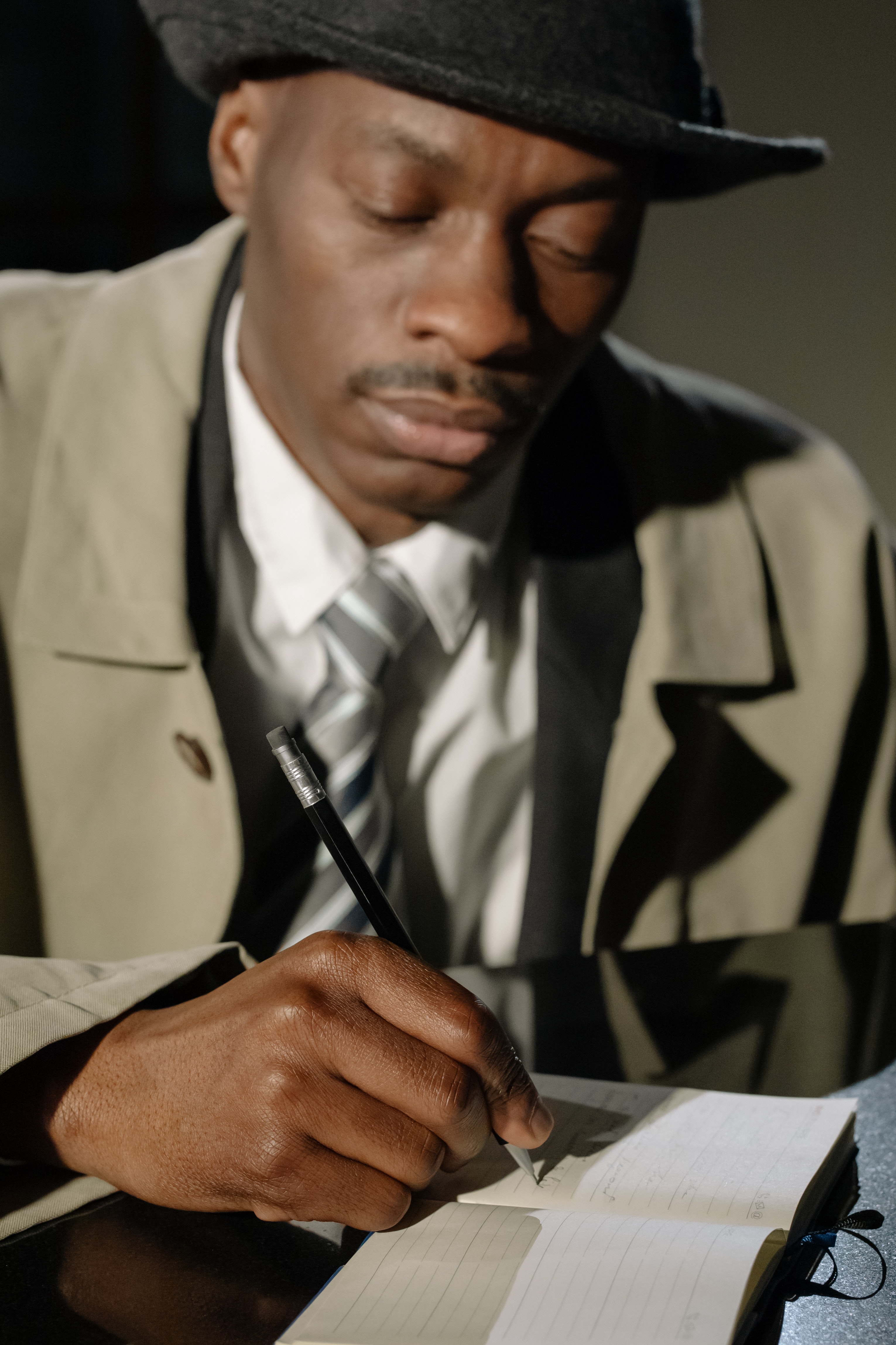 Hombre con sombrero escribiendo en una libreta.