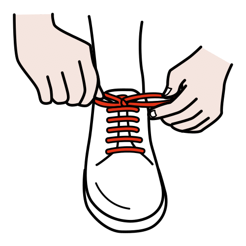La imagen muestra unas manos atando los cordones de unas zapatillas.