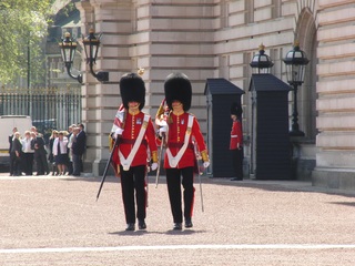 La imagen muestra a dos guardias reales realizando el cambio de guardia en el palacio de Buckingham.