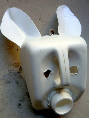  La imagen muestra la parte de arriba de una botella de plástico que ha sido cortada y parece la cabeza de un conejo.