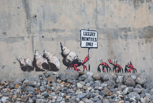 La imagen muestra unos cangrejos ermitaños con un cartel donde se expresa que la zona de playa es sólo para alquiler de lujo