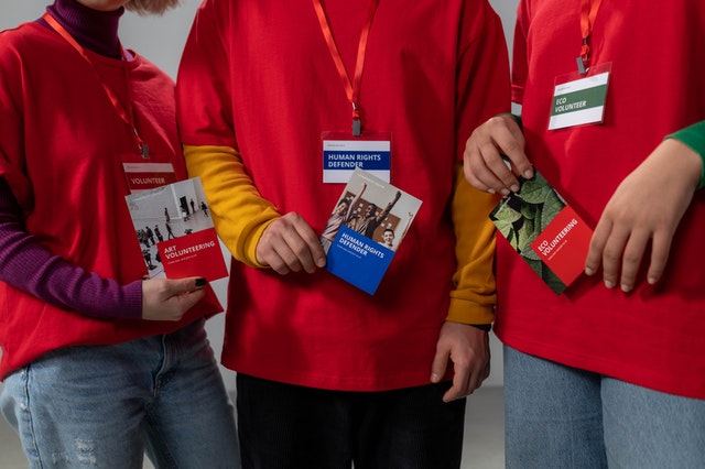 La imagen muestra tres personas mostrando en sus manos  cada una un folleto diferente.