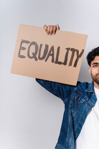 La imagen muestra a un hombre sosteniendo un cartel donde se lee igualdad.