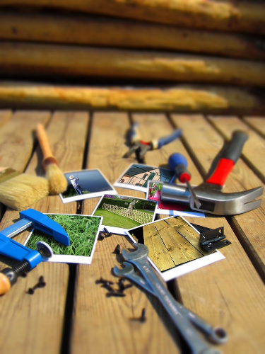 La imagen muestra esparcidas sobre unos tablones de madera distintos tipos de herramientas y fotografías.