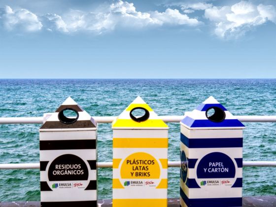 Cubos de reciclaje con el mar de fondo