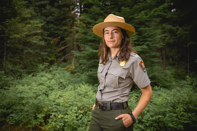 En la imagen puedes ver una mujer guardabosques con su uniforme y su sombrero