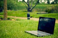 Portátil apoyado sobre hierba al aire libre