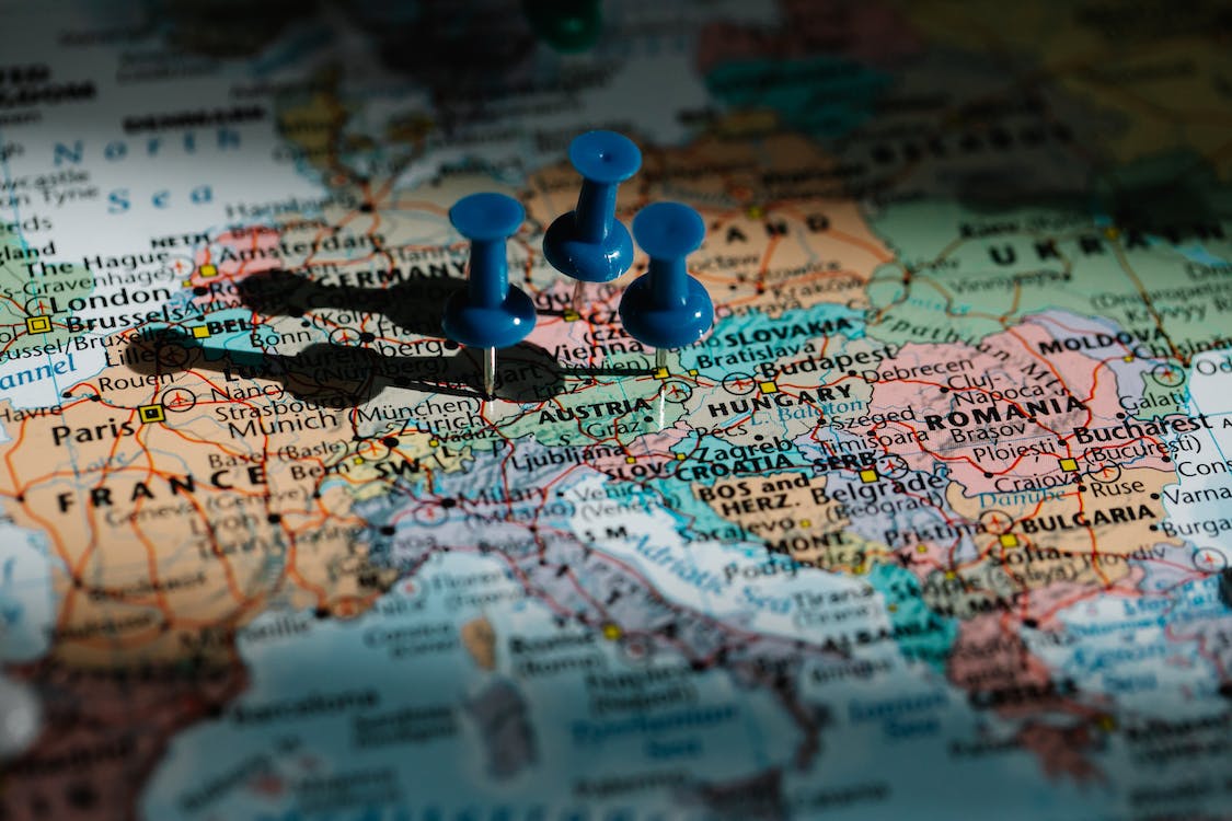 La imagen muestra un mapa de Europa con tres chinchetas de color azul pinchadas en diferentes ciudades. 