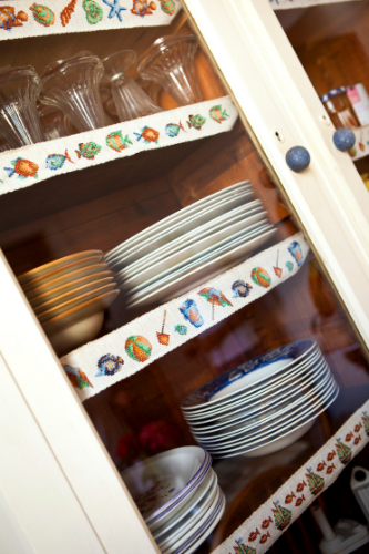 En la imagen puedes ver un armario con puertas de cristal con platos y copas