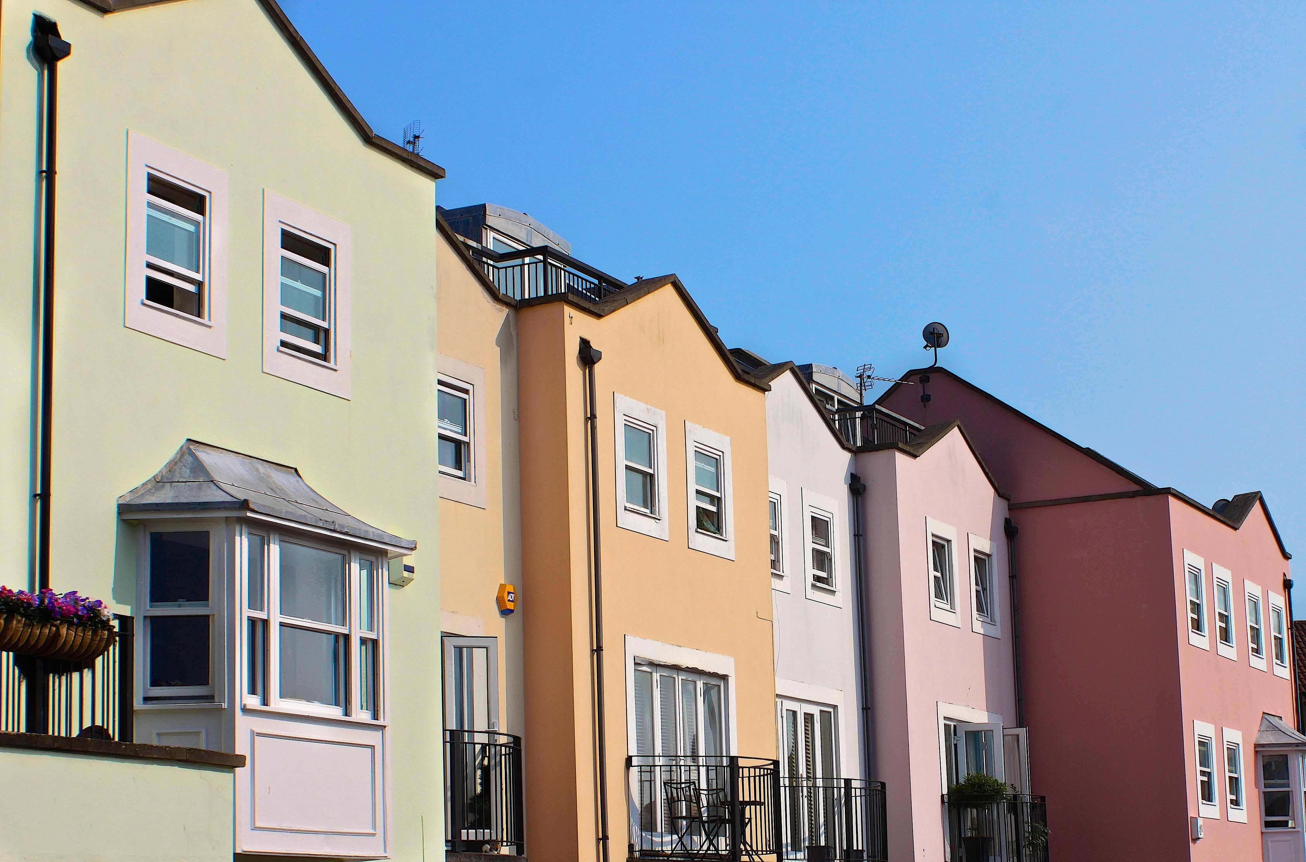 En la imagen puedes ver varias casas, unas junto a otras y cuyas fachadas están pintadas de diferentes colores