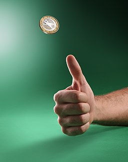 La imagen muestra una moneda tirada al aire