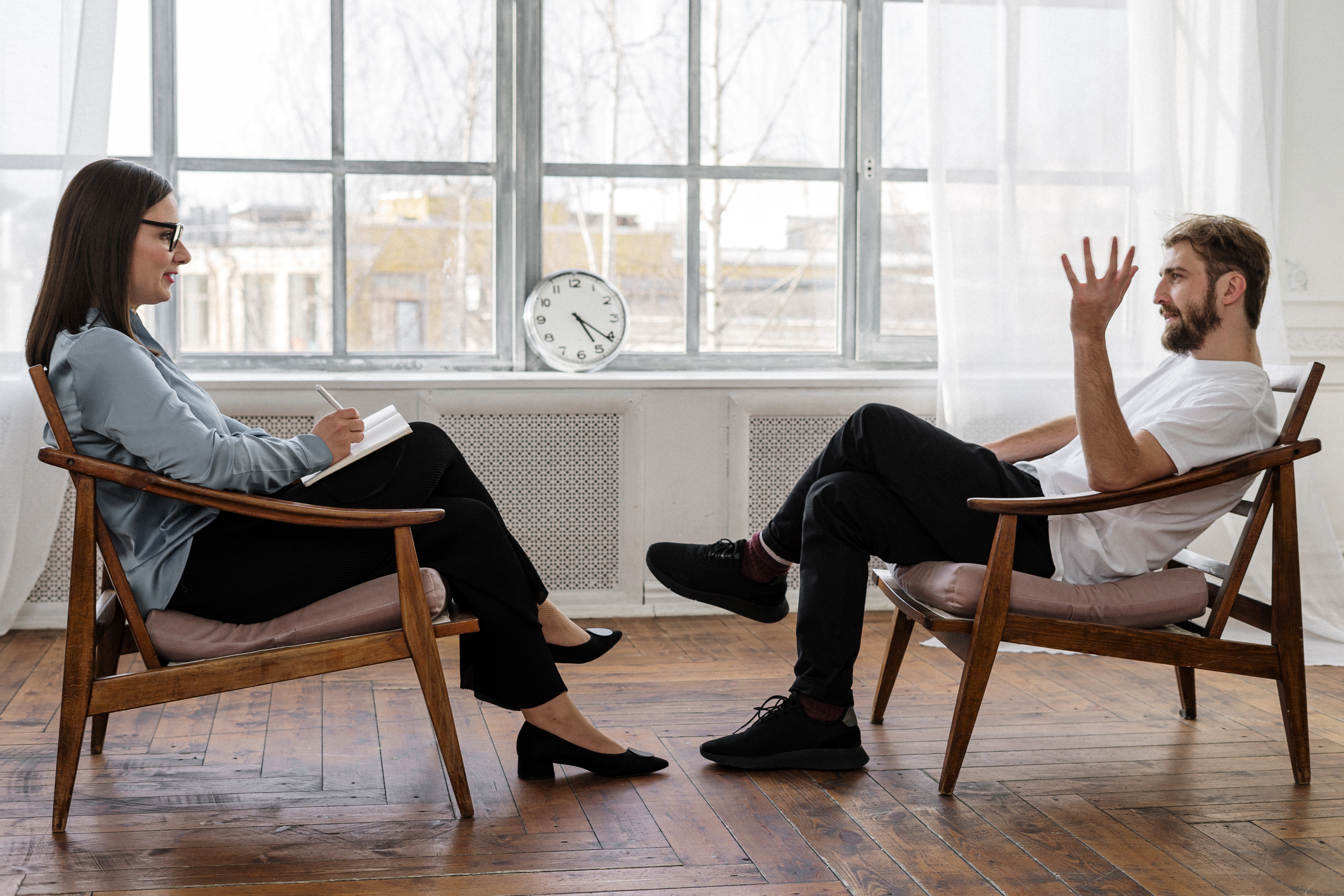 Dos personas hablando sentadas en unos sillones