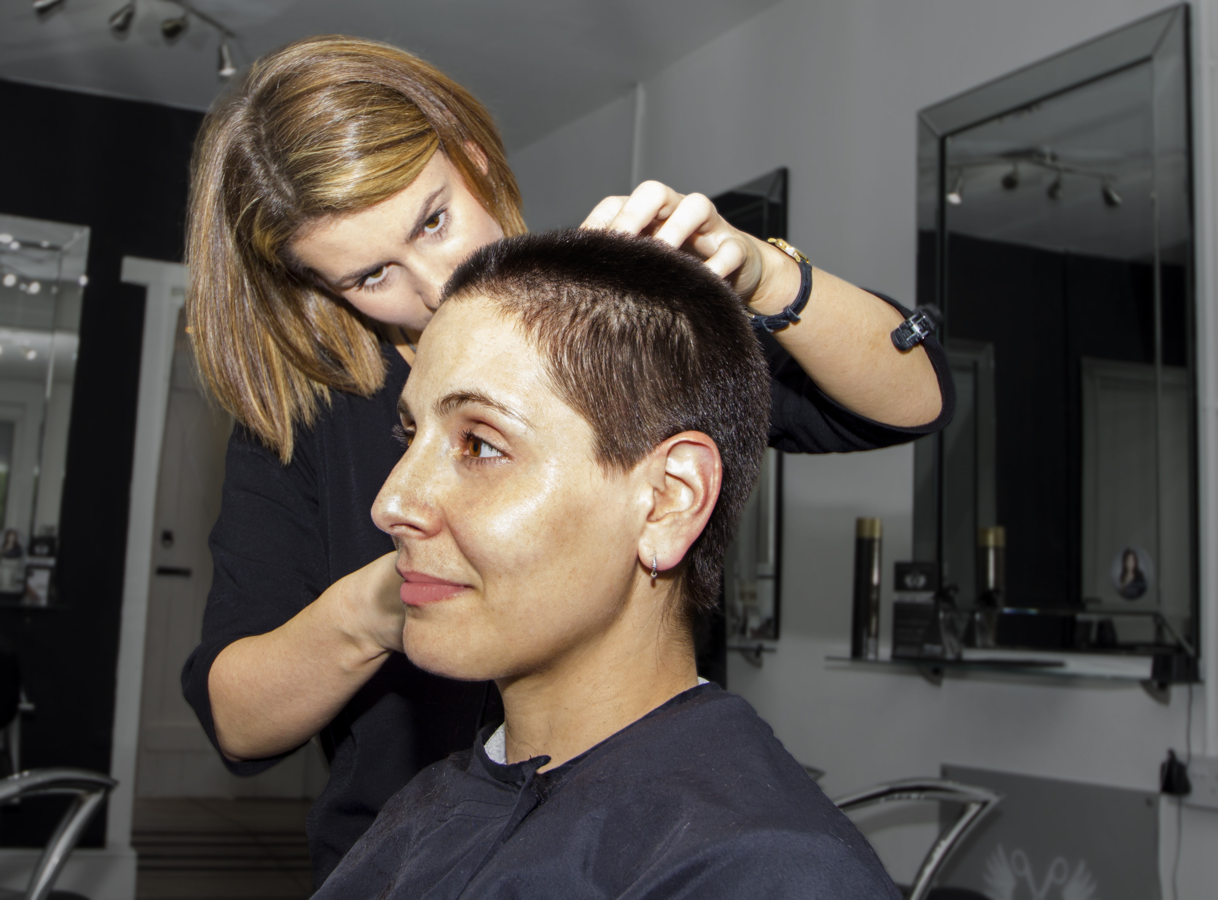 Imagen de una peluquera cortando el pelo a una cliente.