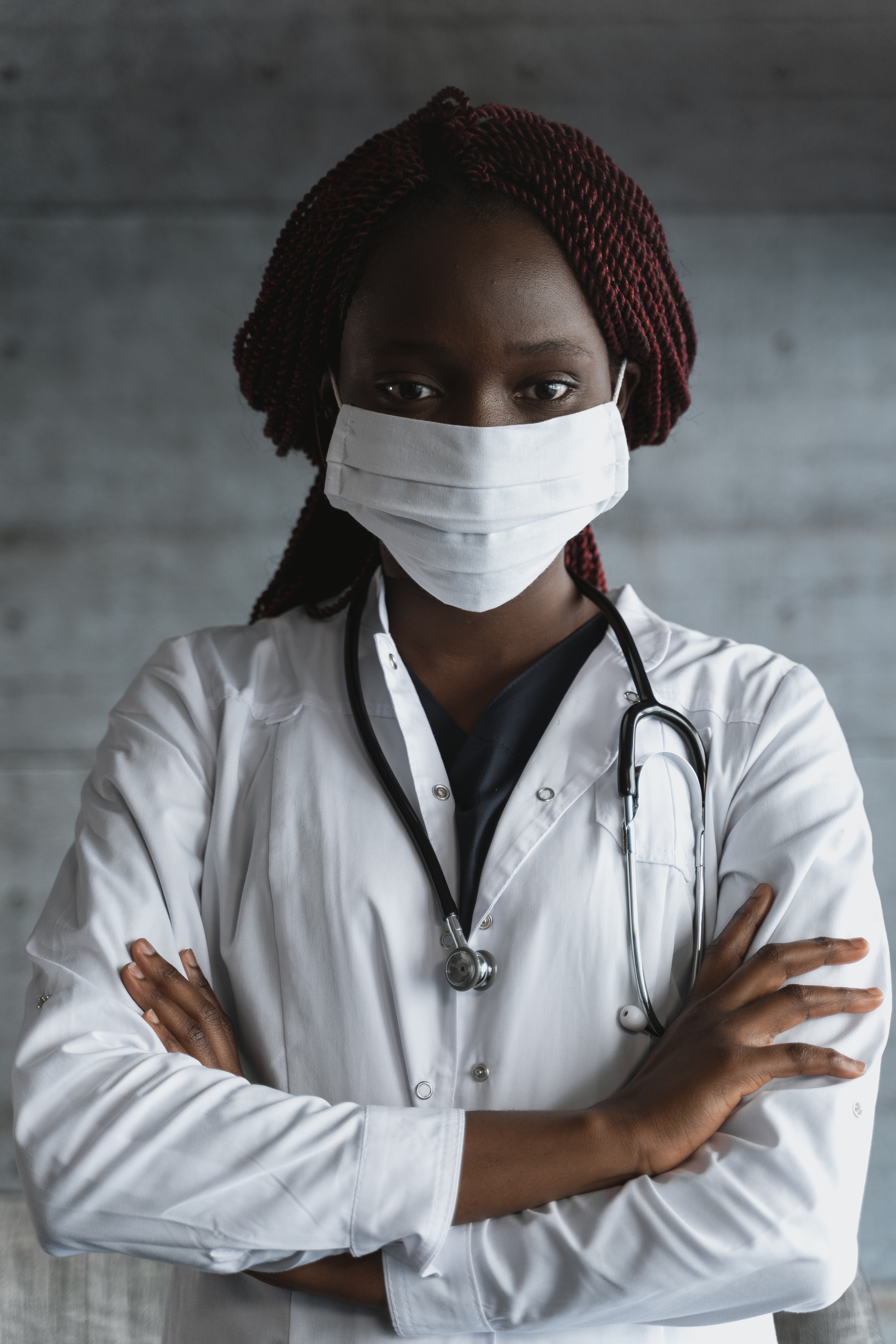 Doctora con una bata blanca y mascarilla.