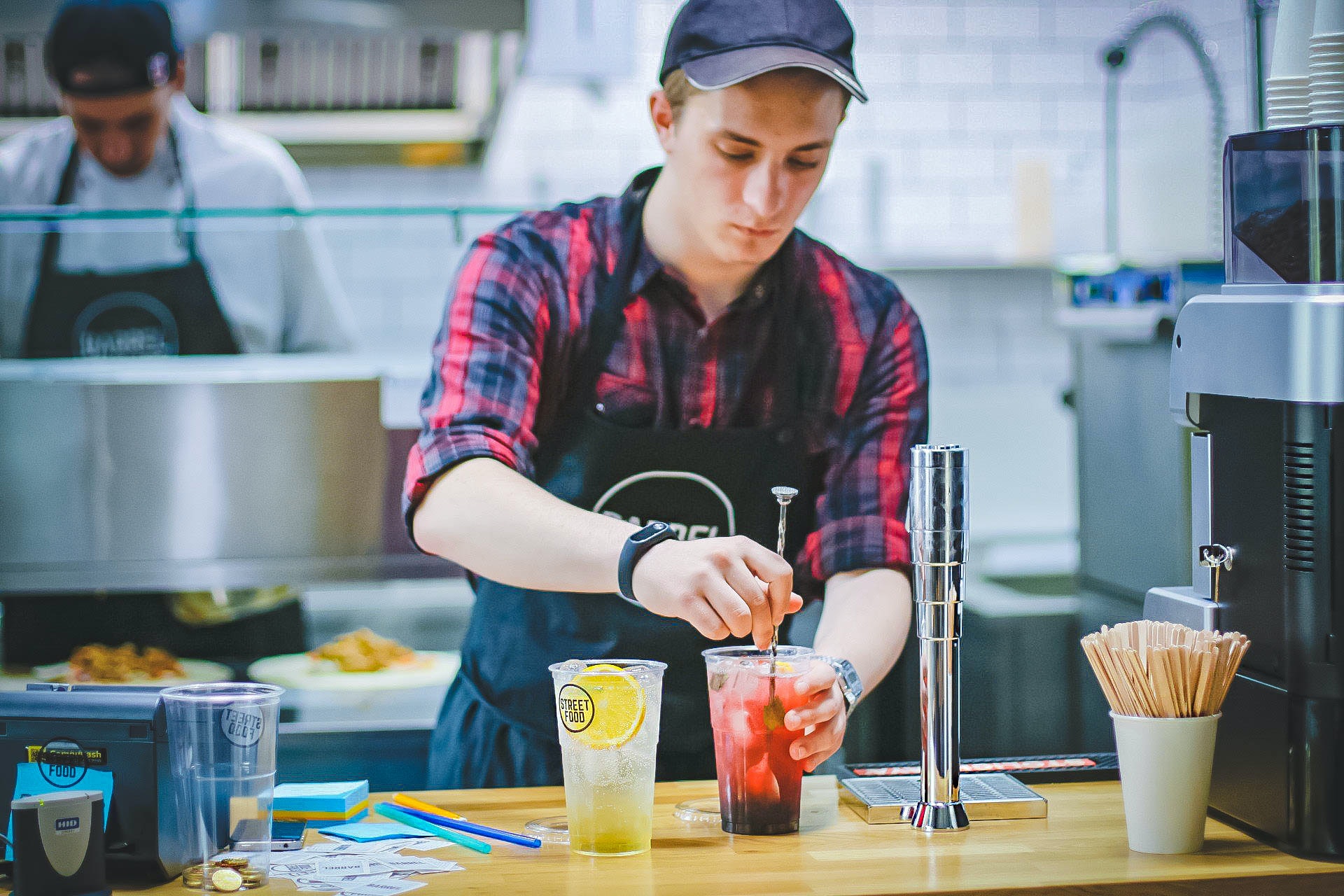 Empleado de un bar preparando dos bebidas.