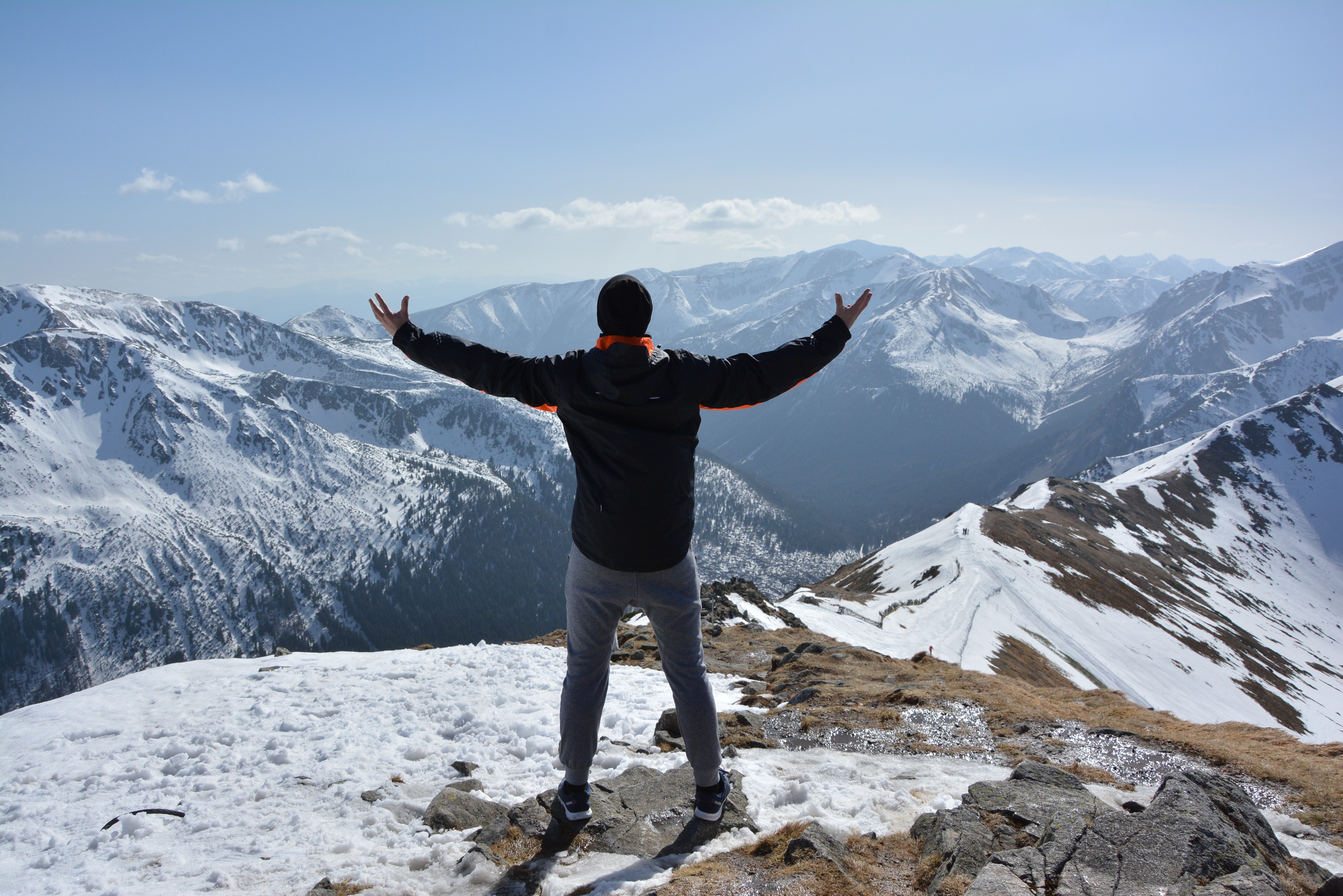 Imagen de una persona muy contenta por llegar a la cima de la montaña.