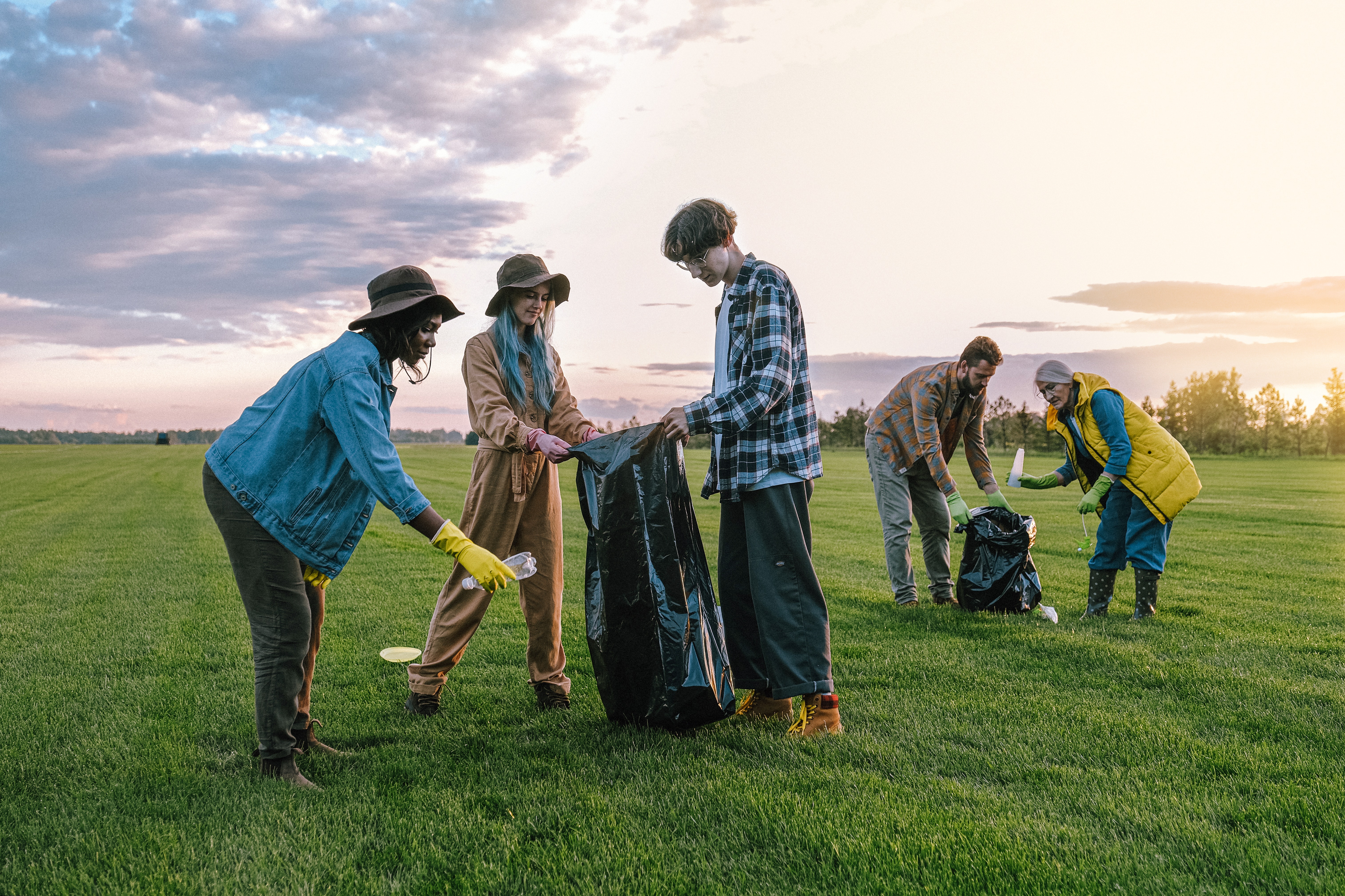 Grupo de personal recogiendo residuos en el campo.