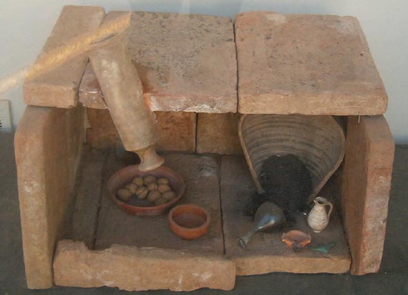 Fotografía de una tumba con urna cineraria y ofrendas