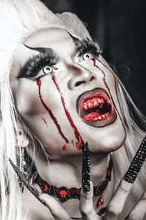 La imagen muestra a una mujer vampiro con la boca ensangrentada y unas uñas enormes de color negro.