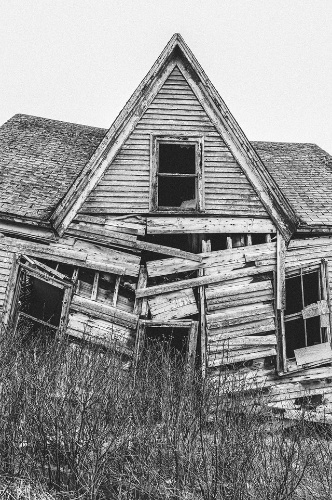 La imagen muestra una casa abandonada hecha de madera y semiderruida. 