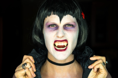 La imagen muestra una mujer vampiro enseñando sus colmillos.