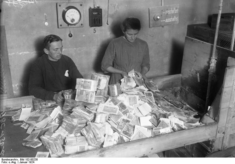 Funcionarios alemanes recolectando papel moneda devaluado