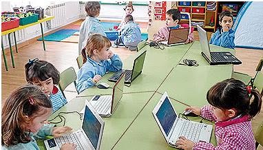 Imagen de una clase de niños pequeños delante de su portátil
