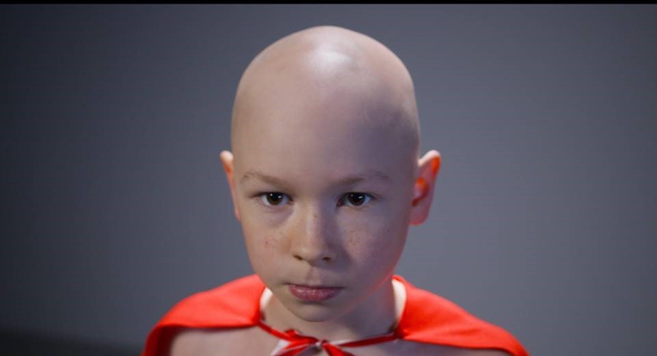 Un niño con una capa de super héroe