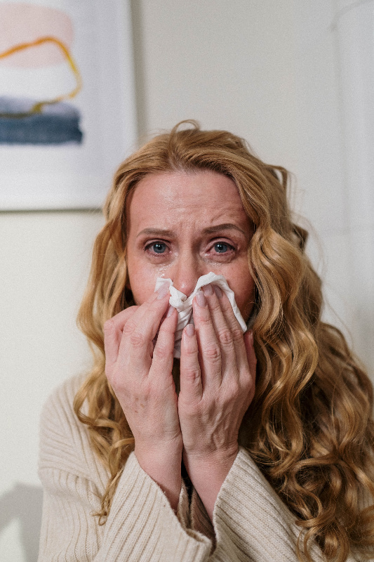 Alergia Una mujer estornudando y con claros signos de alergia.